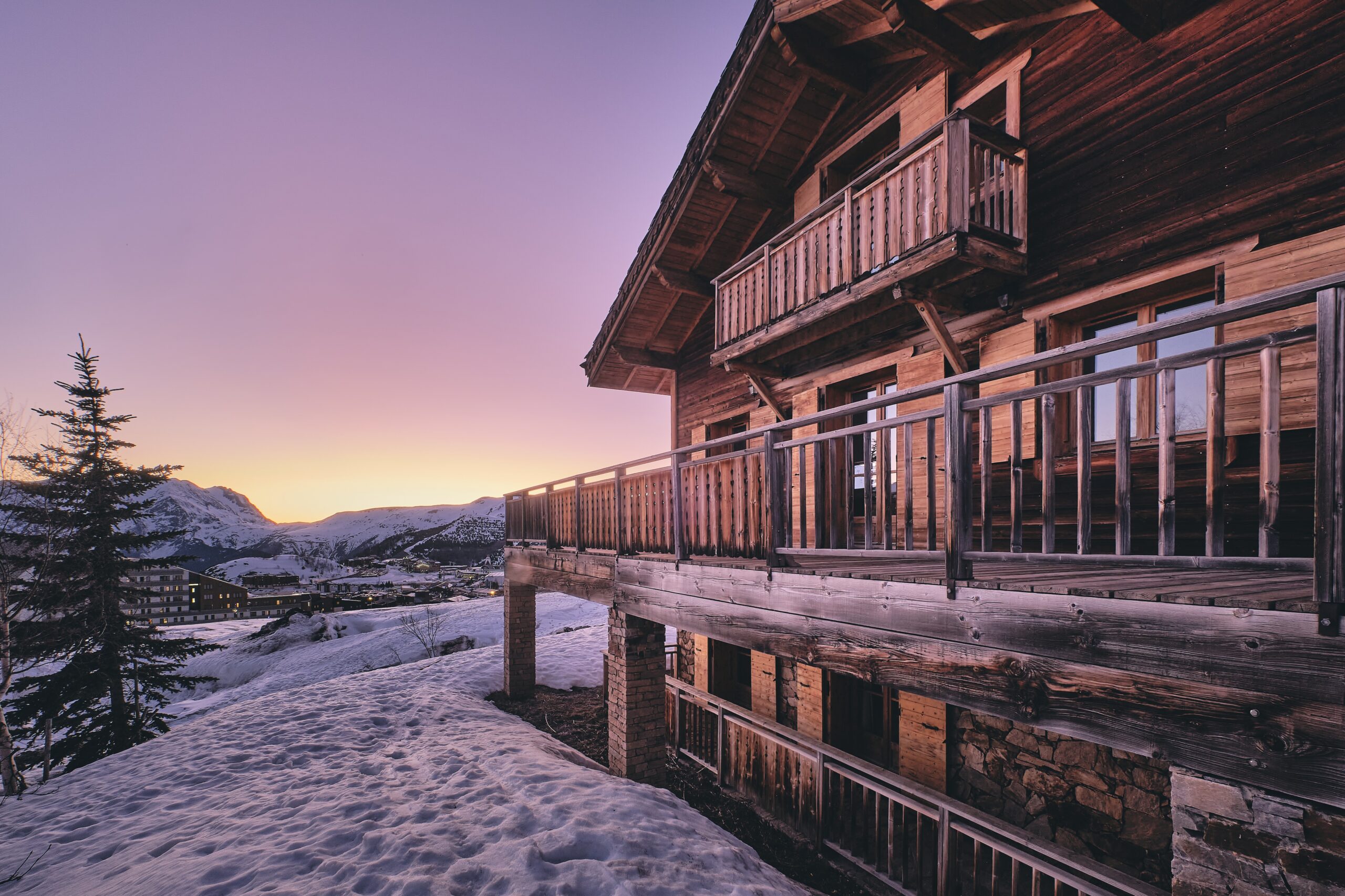 A long shot of the facade of a cabin in Alpe d Huez ski resort in the French Alps during sunrise